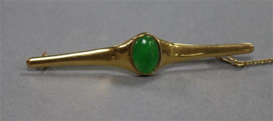 A Chinese yellow metal and jadeite cabochon bar brooch, 62mm.